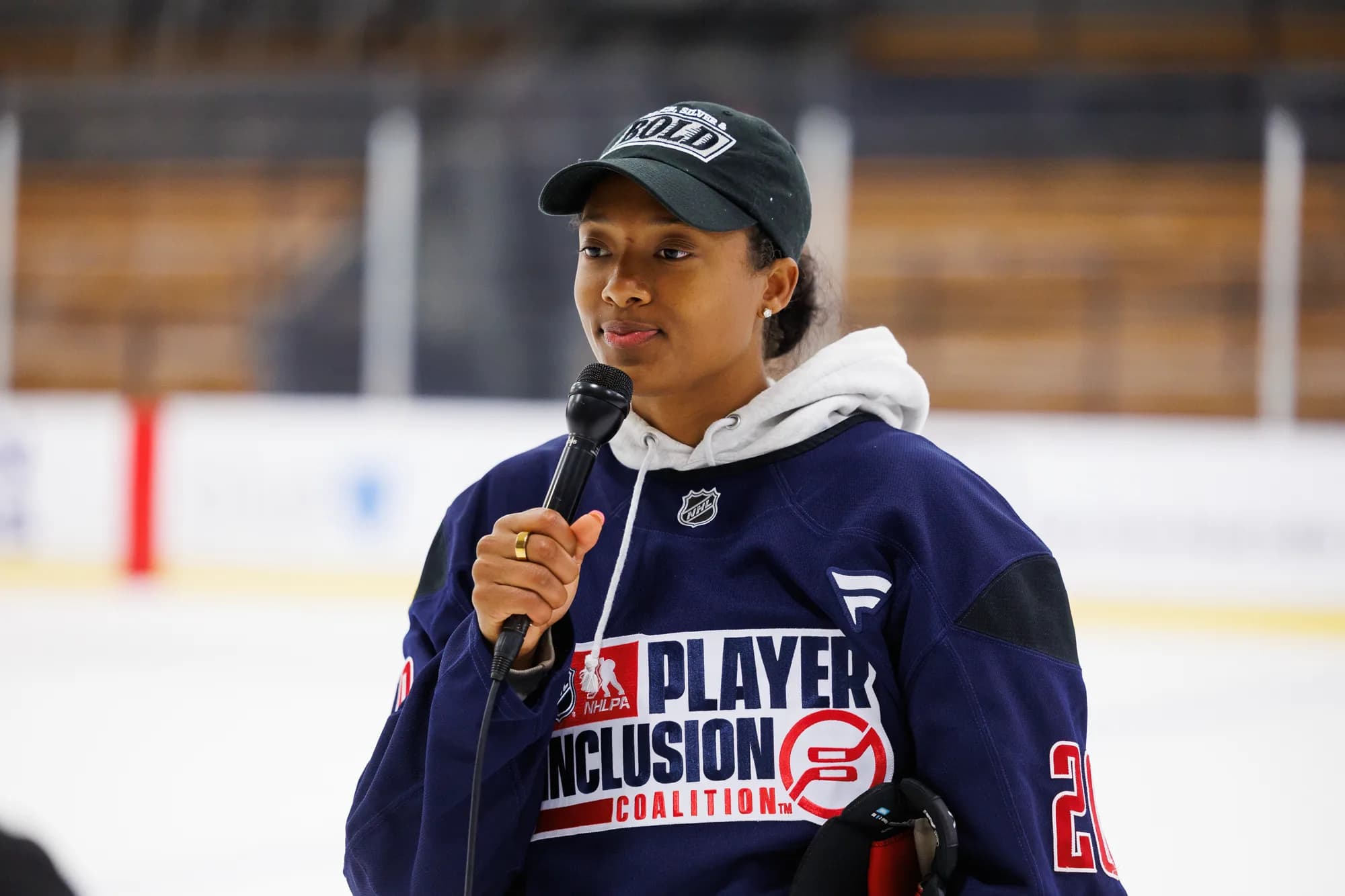 Blake Bolden on the ice in an NHL Player Inclusion Coalition jersey, speaking into a microphone