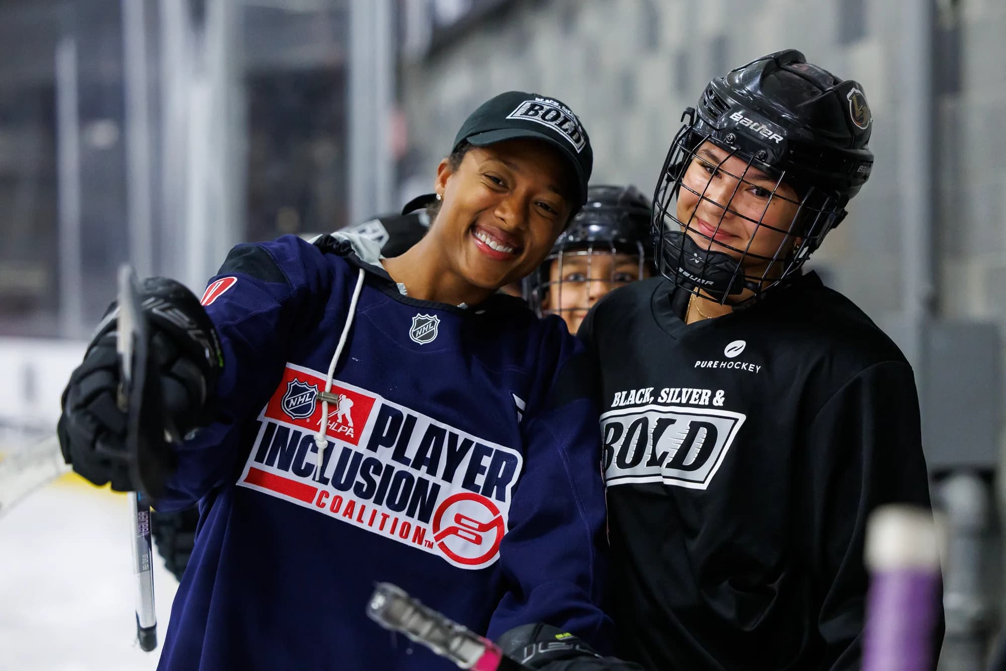 Blake Bolden laughing with young hockey players in Black, Silver and Bold jerseys at the rink