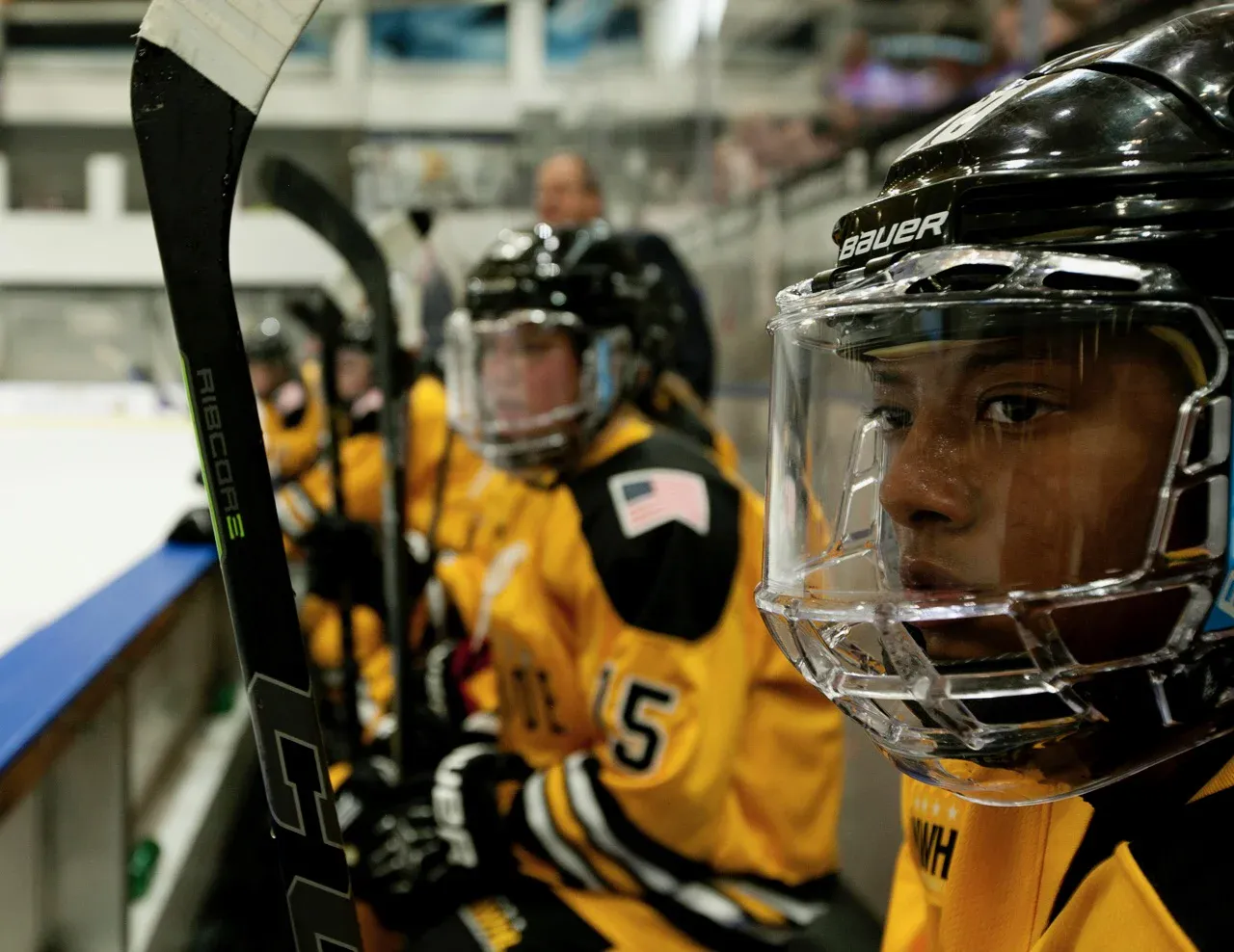 Blake Bolden in a Boston Pride helmet and cage on the bench