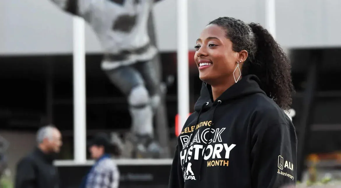 Blake Bolden smiling at a rink in a Celebrating Black History Month hoodie