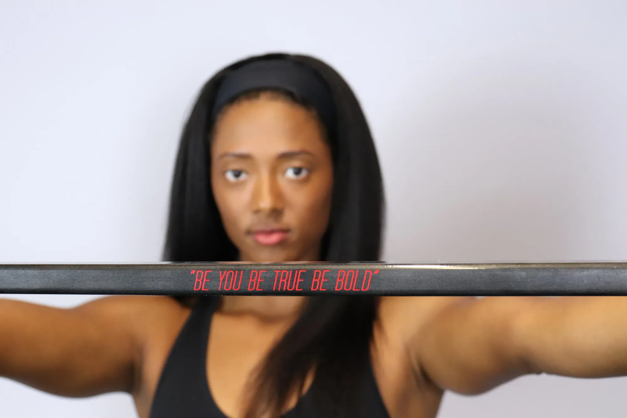 Blake Bolden holding a hockey stick across her shoulders